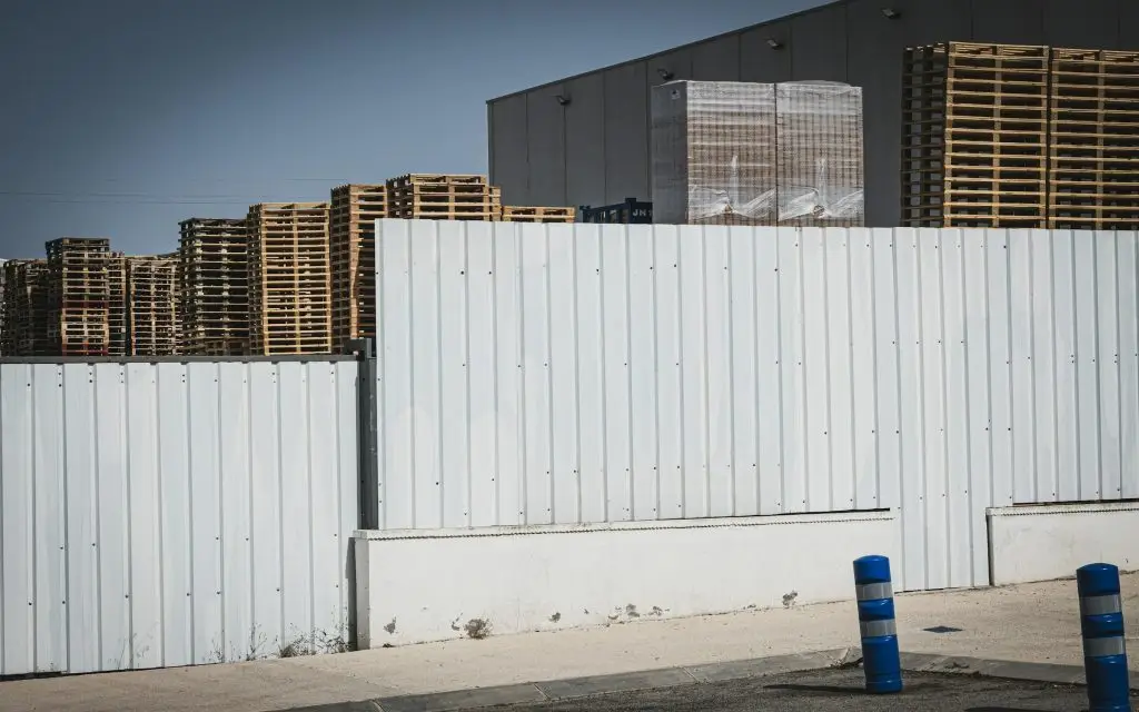 Warehouse yard with perimeter fence and stacked pallets