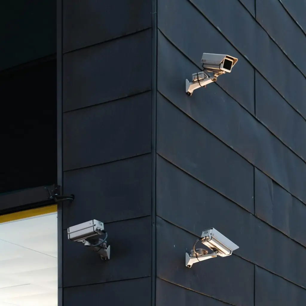 Three security cameras covering the corner of a modern building